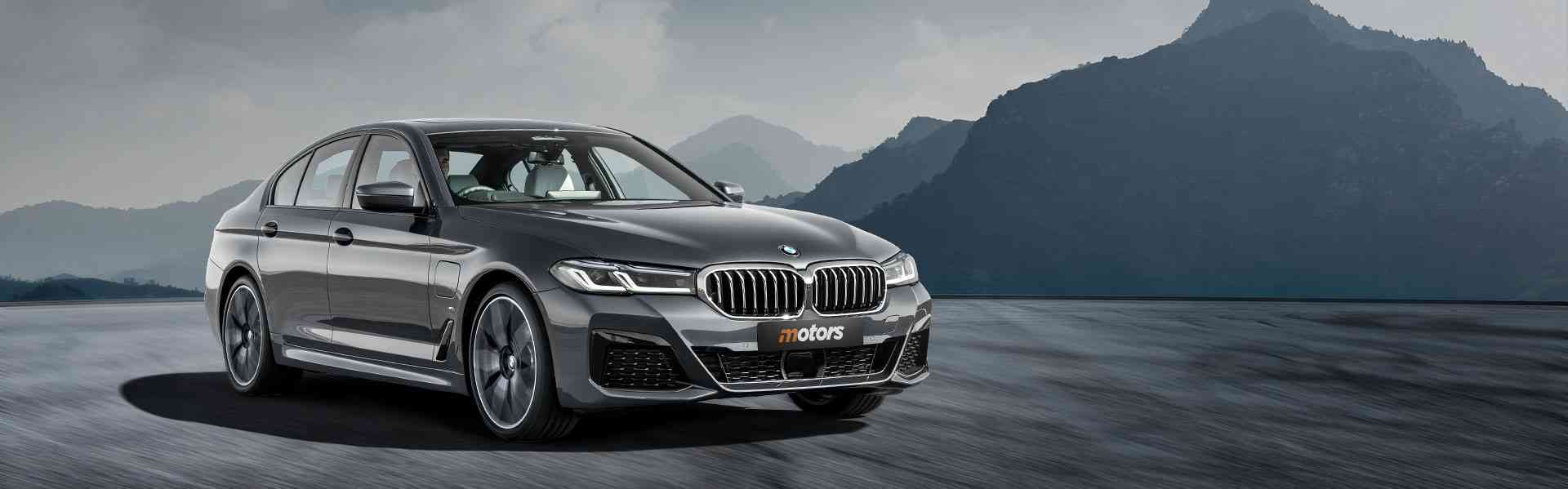 New BMW 5-Series luxury sedan in a scenic mountainous landscape, showcasing sleek design and modern features, relevant to Chinook Auto Sales' vehicle inventory.
