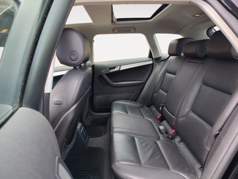Interior view of a 2009 Audi A3 showing rear seating area with black leather upholstery, headrests, and door panel details, highlighting spaciousness and comfort features.