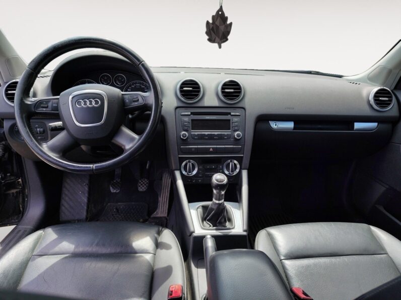 Audi A3 2009 interior showcasing black leather seats, steering wheel with Audi logo, dashboard controls, and gear shift, highlighting luxury features and comfortable design for potential buyers.