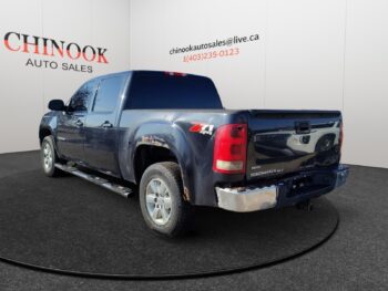 Chevrolet Silverado 1500 pickup truck showcased at Chinook Auto Sales, featuring a dark blue exterior and chrome accents, highlighting its robust design and 4x4 capability.