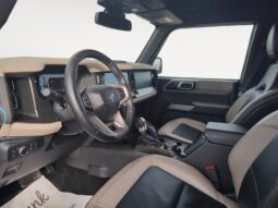 Interior view of a 2022 Ford Bronco Wildtrak Sasquatch showcasing modern dashboard, steering wheel, and seating, highlighting its off-road capability and luxury features.