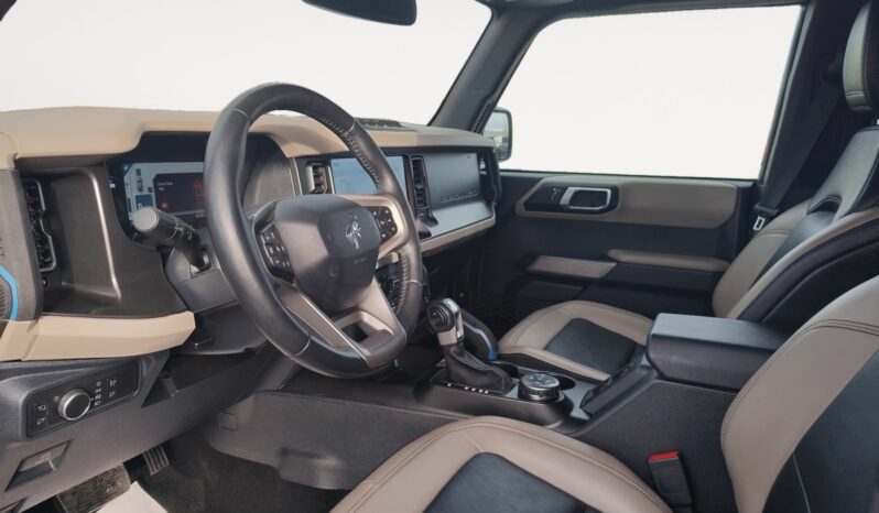 2022 Ford Bronco Wildtrak Sasquatch interior view showcasing modern dashboard, steering wheel, and seating, emphasizing its off-road capabilities and stylish design.