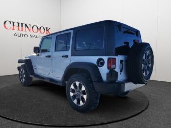 Jeep Wrangler Unlimited showcased at Chinook Auto Sales, featuring a rear-left view with distinctive design elements and branding.