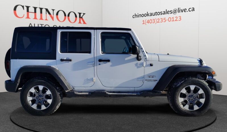 2018 Jeep Wrangler Unlimited Sahara 4&times;4 in white, showcasing side profile with four doors and modern design, displayed against a neutral background with Chinook Auto Sales branding.