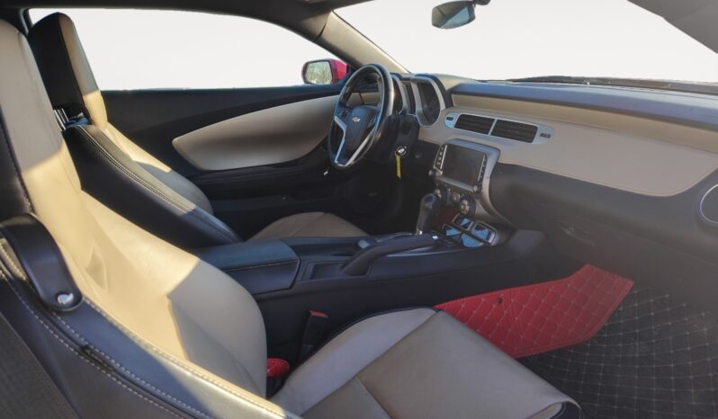 Interior view of a 2014 Chevrolet Camaro 2LT showcasing beige and black leather seats, dashboard with infotainment system, and sporty design elements.