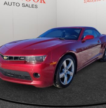 Chevrolet Camaro in red, showcasing sporty design and performance features, displayed at Chinook Auto Sales, a used car dealership in Calgary.