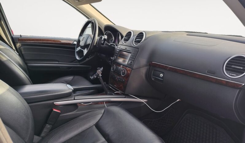 Interior view of a 2010 Mercedes-Benz GL350 Diesel showcasing leather seating, dashboard controls, and wood trim accents, emphasizing luxury and comfort features.