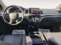 Interior view of a 2022 Honda Odyssey EX-L showcasing the dashboard, steering wheel, touchscreen display, and leather seats, emphasizing family-friendly features and comfort.