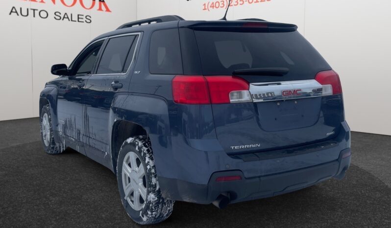 2014 GMC Terrain SLT in Deep Blue Pearl with snow on tires, showcasing the rear view and sleek design, available for CAD $9,995 at Chinook Auto Sales.