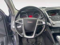 Interior view of a 2014 GMC Terrain SLT, showcasing the steering wheel, dashboard controls, and instrumentation, highlighting its features for potential buyers.