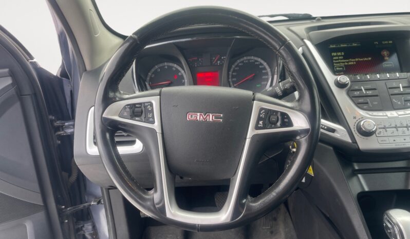GMC steering wheel and dashboard of a 2014 Terrain SLT showcasing interior features and controls.