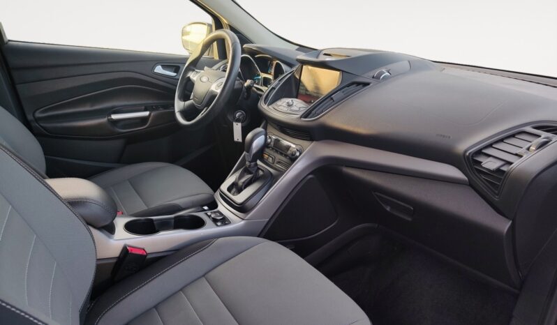 Interior view of a 2015 Ford Escape SE featuring gray seating, dashboard controls, and a touchscreen display, showcasing the vehicle's comfort and functionality for Calgary drivers.