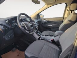 Interior view of a 2015 Ford Escape SE showcasing gray seating, dashboard with steering wheel, and control panel, emphasizing comfort and functionality for Calgary drivers.