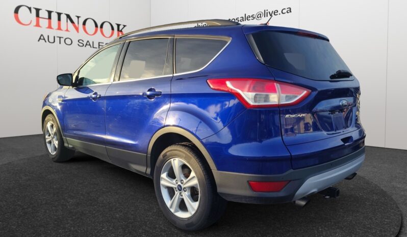 2015 Ford Escape SE in blue, showcasing rear-left view with modern SUV design, available at Chinook Auto Sales, highlighting features for Calgary drivers.