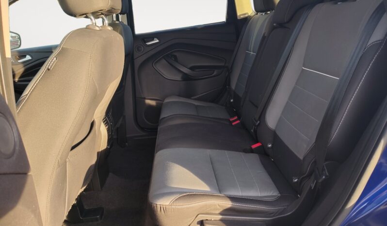 Interior view of the rear seating area in a 2015 Ford Escape SE, featuring gray fabric upholstery and spacious legroom, highlighting comfort and utility for passengers.