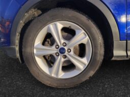 Close-up of the front left wheel of a blue 2015 Ford Escape SE, showcasing the alloy rim and tire.