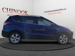 2015 Ford Escape SE in blue, side view, showcasing SUV design and Chinook Auto Sales branding.