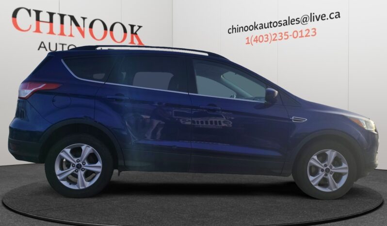 2015 Ford Escape SE in blue, side view, showcasing SUV design and features, with Chinook Auto Sales branding in the background.