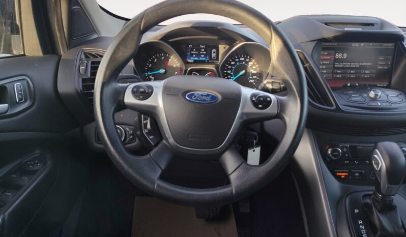 Ford steering wheel and dashboard of a 2015 Ford Escape SE with instrument cluster and infotainment system displayed.