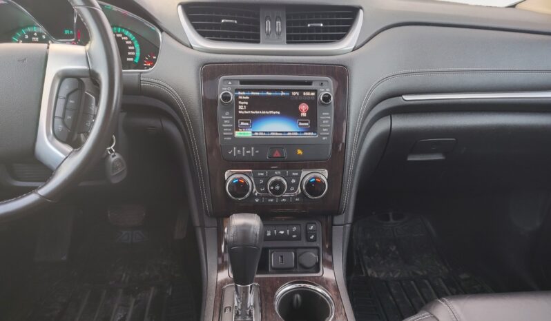 Interior view of 2017 Chevrolet Traverse 2LT AWD center console featuring touchscreen display, climate controls, and gear shift, showcasing a modern SUV design suitable for Calgary families.
