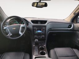 2017 Chevrolet Traverse 2LT AWD interior featuring black leather seats, dashboard with touchscreen display, and Chevrolet logo on steering wheel, highlighting comfort and modern design for Calgary families.