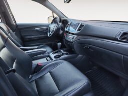 Interior view of a 2016 Honda Pilot EXL-R, featuring black leather seats, dashboard controls, and spacious layout, highlighting its family-friendly design and comfort for passengers.