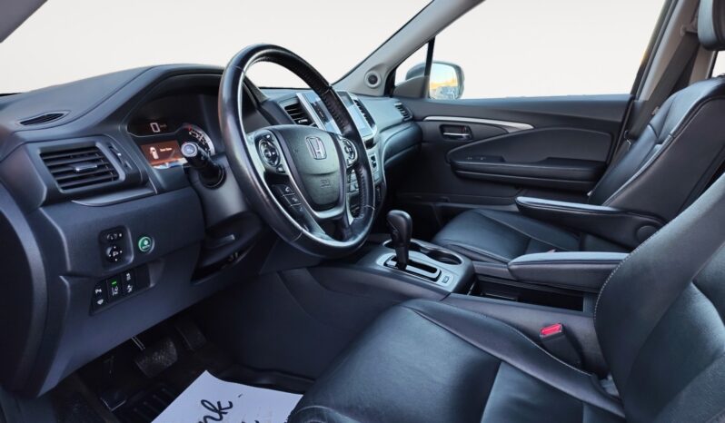 Interior view of a 2016 Honda Pilot EXL-R SUV featuring black leather seats, steering wheel with Honda logo, dashboard controls, and spacious cabin design, highlighting comfort and functionality for families.