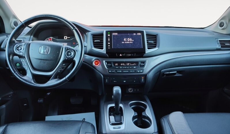 Honda Pilot EXL-R interior view featuring steering wheel, dashboard, touchscreen display, and gear shift, highlighting premium features for family comfort and convenience.